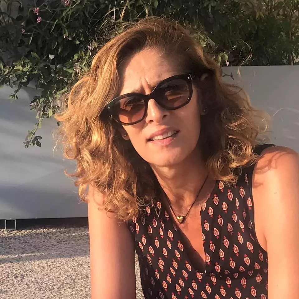 אישה עם משקפי שמש ושיער מתולתל בשמש