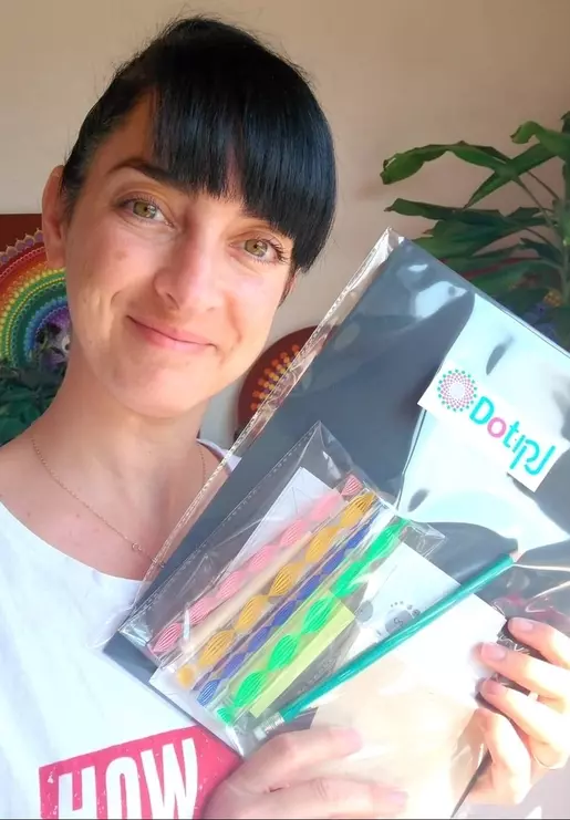 אלה ברקת בן ארי מחזיקה ערכת חומרים לציור נקודות