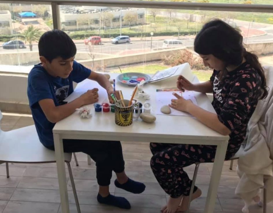 שני ילדים מציירים נקודות ליד שולחן במרפסת