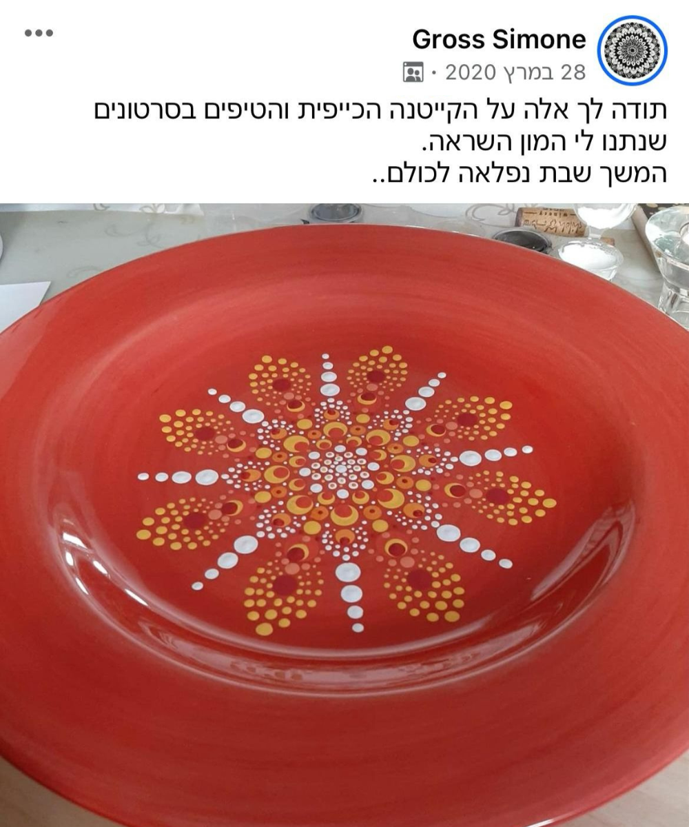 מנדלה מנוקדת בגווני כתום ולבן על צלחת אדומה