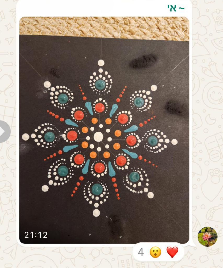 תלמידה משתפת מנדלה מנוקדת בכתום וטורקיז על רקע שחור