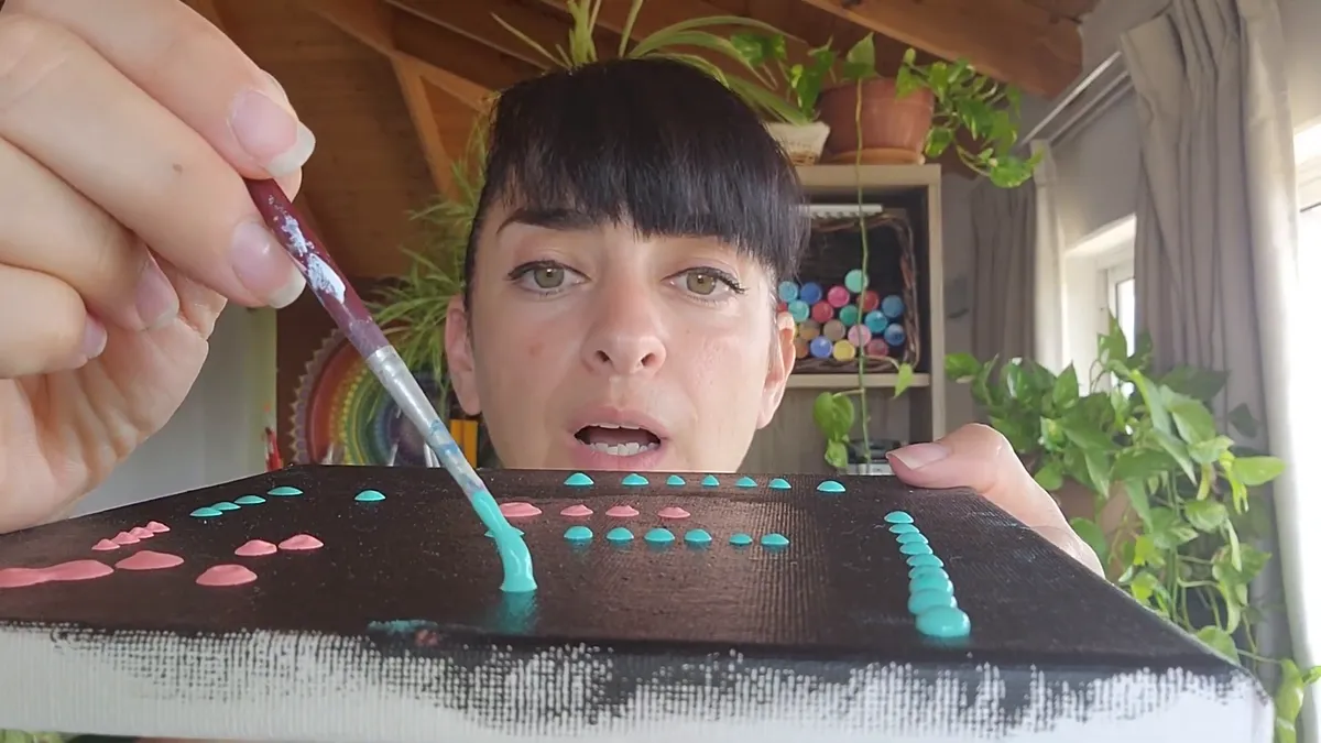 ניקוד נקודה נפוחה בטורקיז במכחול קטן על קנבס שחור
